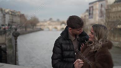 Romantic couple embracing in Paris France with Seine river and bridges in