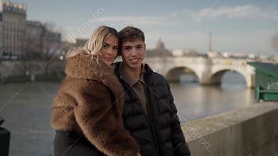 Romantic couple posing in Paris France with Seine river and bridges in