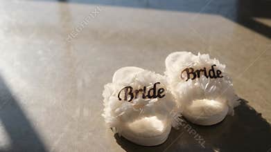 White fluffy bride slippers on concrete floor
