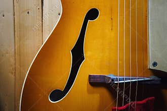 Details of an old jazz guitar on a wooden wall