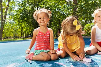 Cute little girls draw with chalk