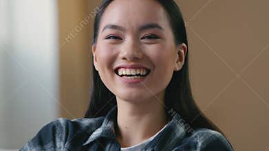 Asian woman smiling laughing looking at camera joyful toothy smile Korean Japanese Chinese girl amused by funny joke