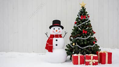 Snowman and Christmas tree with presents on snowy ground