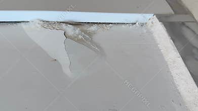 Mold damage on white wall showing cracked paint and moisture buildup in interior setting