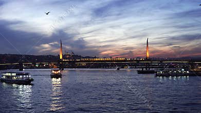 Illuminated bridge crossing Bosphorus during colorful dramatic sunset evening