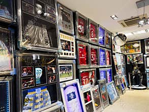 Sports memorabilia shop wall filled with framed jerseys, photos, and memorabilia in display