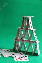 House of playing cards on green background