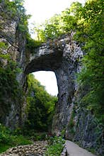 A massive limestone arch carved by Cedar Creek, showcases stunning geological history and natural beauty near Natural Bridge in