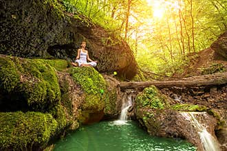 Relaxation in forest at the Waterfall. Ardha Padmasana pose
