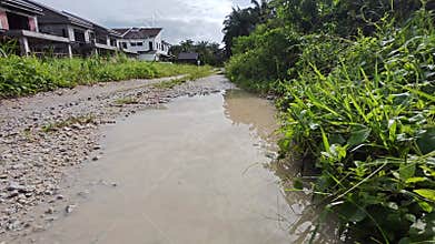 stagnant pool of rainwater along the diminishing perspective rural pathway into the rural countryside
