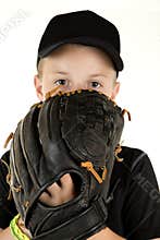 Young boy baseball pitcher peering over glove ready to pitch