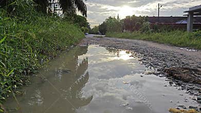 stagnant pool of rainwater along the diminishing perspective rural pathway into the rural countryside