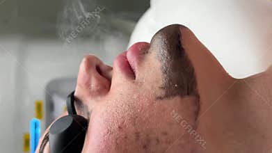 Young woman getting carbon laser facial at beauty clinic. Professional skincare