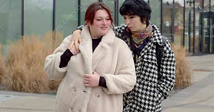 white bride-to-be and asian friend arm-over-shoulder pose prague