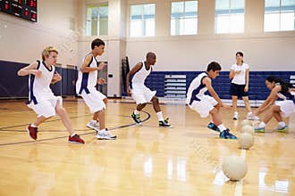High School Students Playing Dodge Ball In Gym