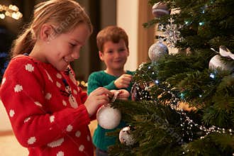 Children Decorating Christmas Tree At Home