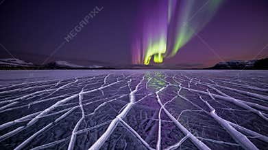 aurora borealis over frozen lake, vivid green and purple curtains swirling above cracked ice, radial fissures leading