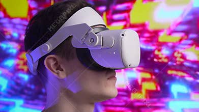 Close up cute young man uses interactive VR headset, amaze and enjoys virtual reality. Wearing VR glasses or helmet to watch 360