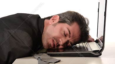 Businessman resting head on laptop