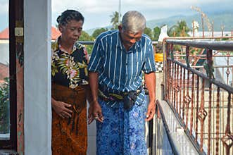 Elderly Couple Leaving Family Shrine After Completing Traditional Prayer