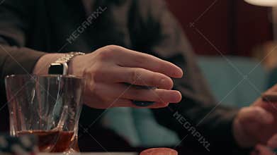 Close up drunk nervous Caucasian male gambler smoking cigar holding poker chip skilled unknown man guy player tokens