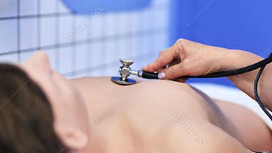 Medical student learning examination skills on a patient dummy with stethoscope