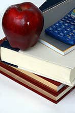 Books, calculator and apple