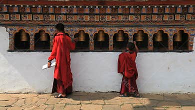 Buddhist monk in bhutan and the prayer wheels