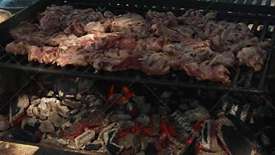 Grilling marinated meat on charcoal barbecue grill