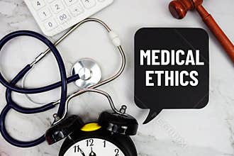 Medical Ethics text written on notepad with stethoscope and gavel on marble background