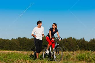 Man and woman jogging and with bicycle