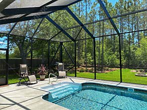 Homeowner\'s Swimming Pool Cage Enclosure in Florida. Bronze color.