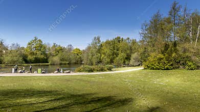 The Doctor Park in Randers. people sit and drink coffee in nature. picnic in the park. lake and forest in the background