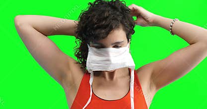 Young woman putting a face mask on in order to prevent contagion of the COVID-19