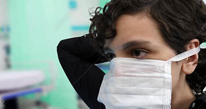 Young woman putting on a face mask to prevent viral contagion at a hospital