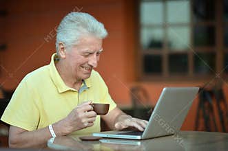 Portrait of smiling senior man using laptop
