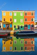 Lovely house facade and colorful walls in Burano, Venice. Burano island canal, colorful houses and boats, Venice landmark, Italy.