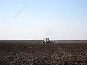 Plowed field by tractor in brown soil on open countryside nature