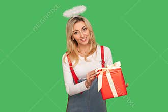 Happy birthday! Portrait of angelic beautiful adult woman with halo above head holding gift box and smiling