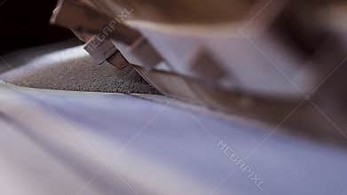 Close-up of bulk material on factory conveyor. Stock footage. Powder raw materials for construction work are poured on