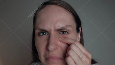 Portrait of female popping pimple