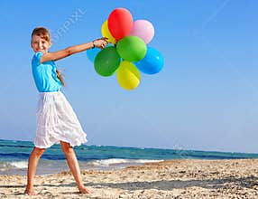 Child playing with balloons at the beach