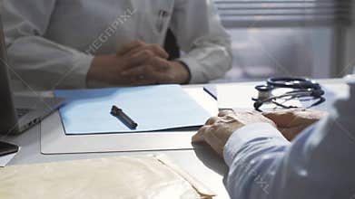 Female doctor holding a patient`s hands and comforting him