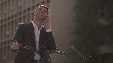 Handsome young businessman on the ebike using mobile phone
