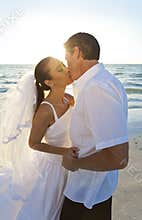 Married Couple Kissing at Sunset Beach Wedding