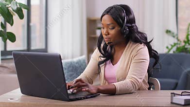 Woman with headset and laptop working at home