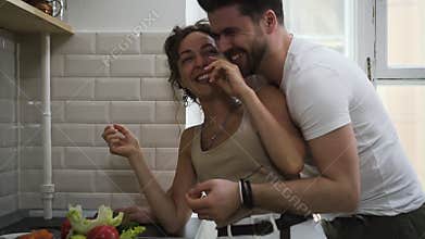 Cheerful couple hugging flirting in kitchen having romantic relationship Sbbd. wife and husband