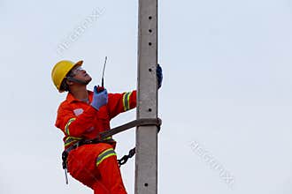 Electricians work on high-voltage electricity poles