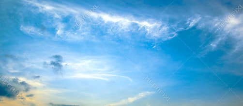 Panorama bright spring sunset with blue sky, white clouds and red sun