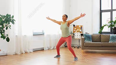 Woman doing jumping jack exercise at home